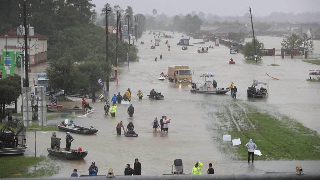 People walk the streets as they evacuate their homes in Houston, Texas, after the area was flooded by Hurricane Harvey