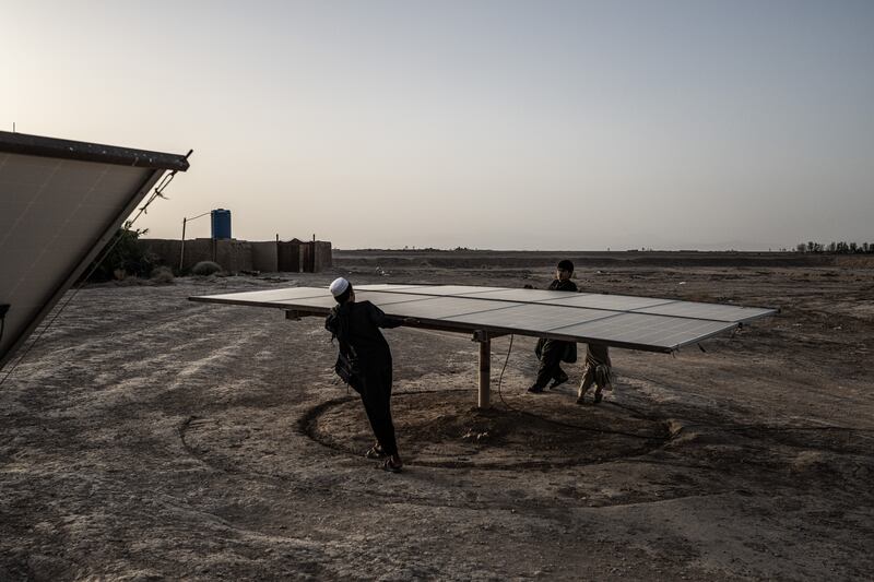 Relatives of Abdul Khaliq rotate a solar panel at the depot where he once prospered from fixing and selling the water pumps that enabled southwest. Photograph: Bryan Denton/The New York Times
