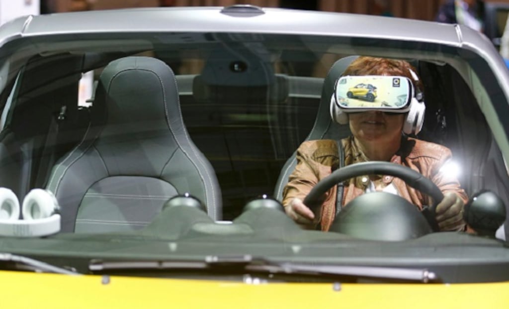 A woman uses virtual reality goggles while sitting in a 'smart fortwo cabrio' car prior to the Daimler annual shareholder meeting in Berlin, Germany, today. Photograph: Hannibal Hanschke/Reuters