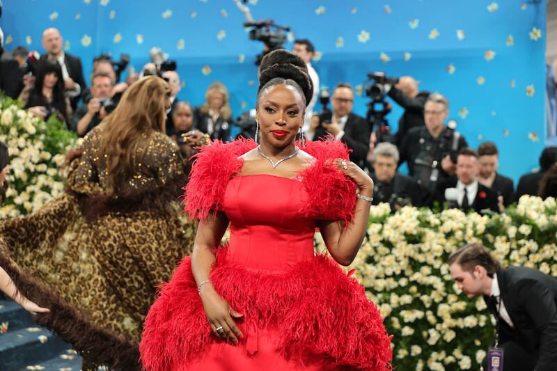 Chimamanda Ngozi Adichie in red on the blue carpet. Photograph: Dia Dipasupil/Getty