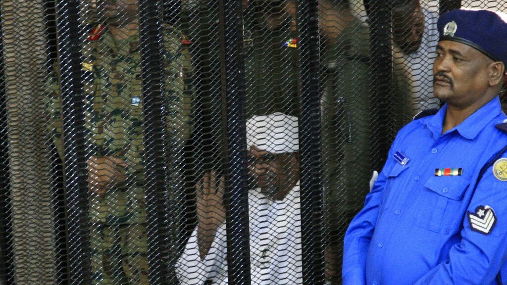Sudan’s deposed military ruler Omar al-Bashir sits in a defendant’s cage during the opening of his corruption trial in Khartoum on Monday. Photograph: Ebrahim Hamid/AFP/Getty Images