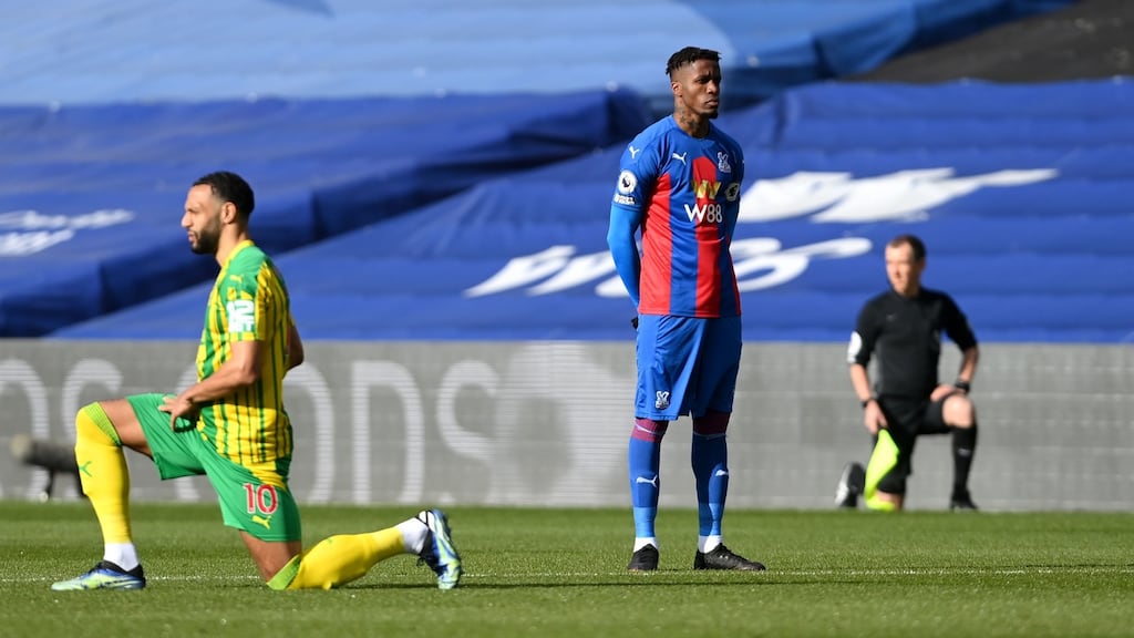 Crystal Palace’s Wilfried Zaha stands while the rest of his team mates and the West Brom players take a knee at Selhurst Park. Photograph: PA