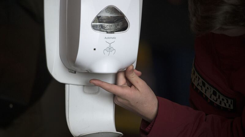 A visitor to Trinity College using a hand sanitiser following a reported case of coronavirus on campus. Photograph: Dave Meehan/The Irish Times.