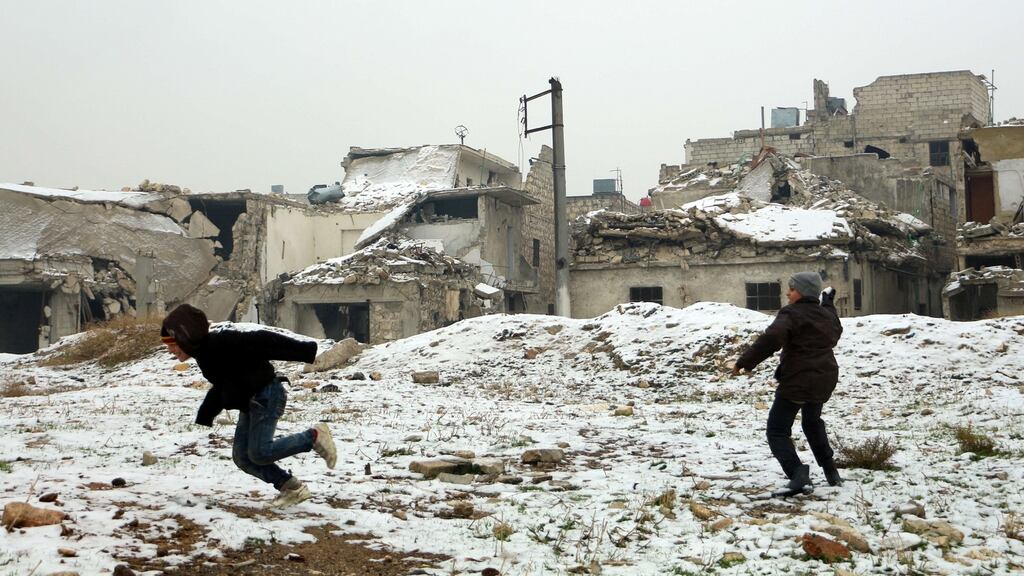 Syrian boys play with snow following a storm in the northern Syrian city of Aleppo on last week. Photograph: KAram Al Masri/AFP/Getty Images