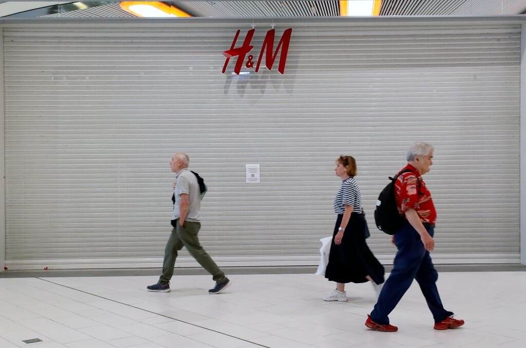 People walk past the closed H&M store in a shopping centre in St Petersburg, Russia. Photograph: EPA