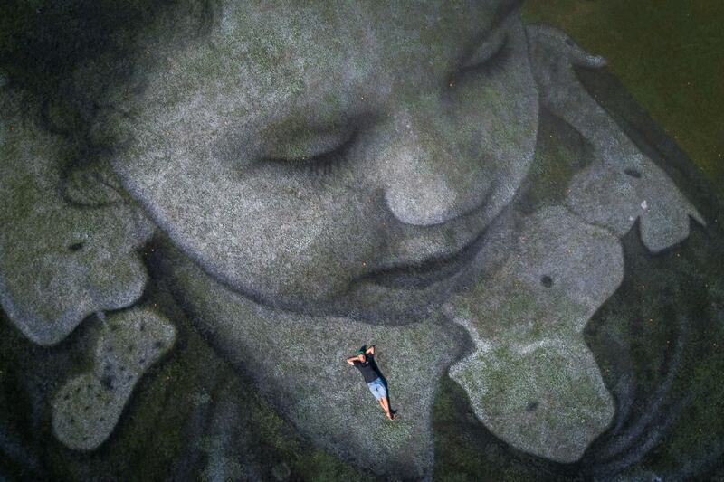 Saype: the artist on his giant fresco in aid of SOS Méditerranée. Photograph: Fabrice Coffrini/AFP/Getty