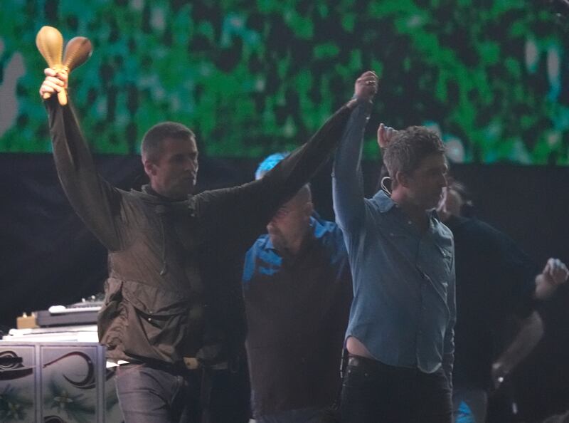 Oasis: Liam and Noel Gallagher hold hands as they take to the stage at the Principality Stadium, Cardiff, for the band's long-awaited reunion tour. Photograph: Jordan Pettitt/PA Wire
