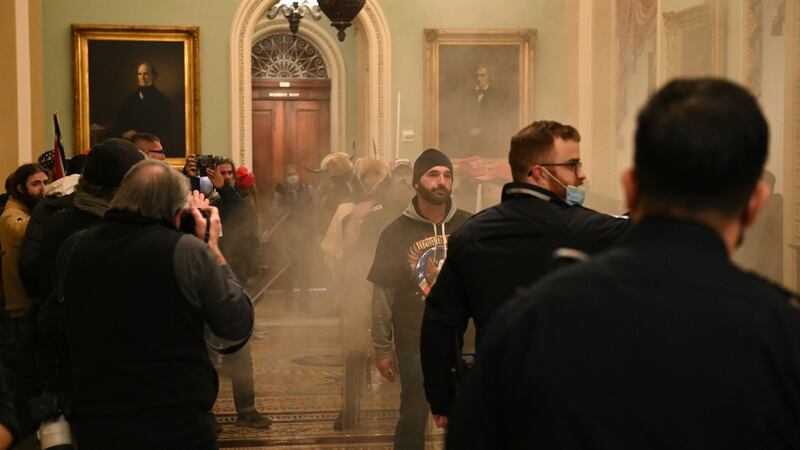 Supporters of US president Donald Trump enter the US Capitol as smoke fills the corridor. Photograph: Saul Loeb / AFP