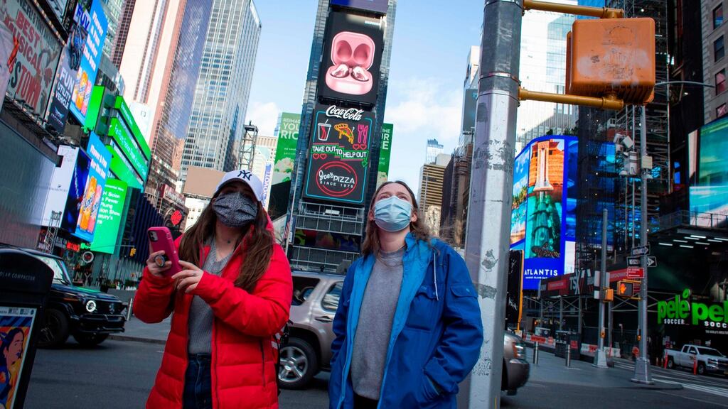 Tourists  wearing  face masks  when visiting Times Square in New York. Photograph:  Kena Betancur/AFP via Getty Images