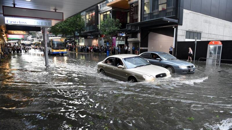 Cars attempt to drive through flood water in the Brisbane central business district after a severe thunderstorm swept through the city. Photograph: Dan Peled/EPA.