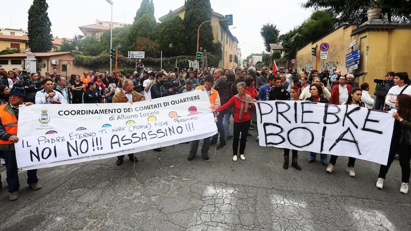 People gather outside the church of Lefebvriani to protest with a banner which says ‘Priebke Executioner’ in Albano Laziale, Italy. Photograph: Ernesto Ruscio/Getty Images