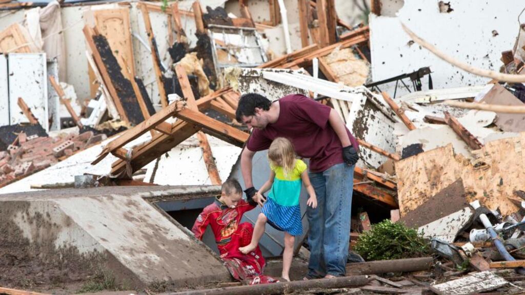 A man and two children exit a shelter after debris was cleared after a tornado struck Moore, Oklahoma last night. Photograph: Reuters