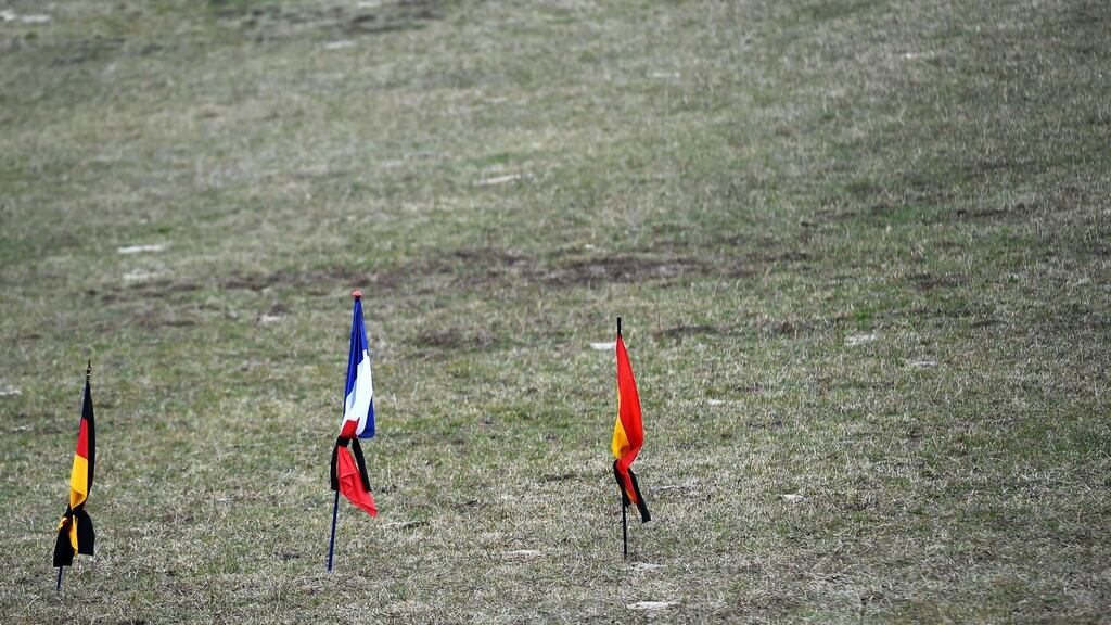 German, French and Spanish flags in a field in the southeastern French village of Le Vernet, the closest to the site where the German Airbus A320 went down. Photograph: Anne-Christine Poujoulat/AFP/Getty Images