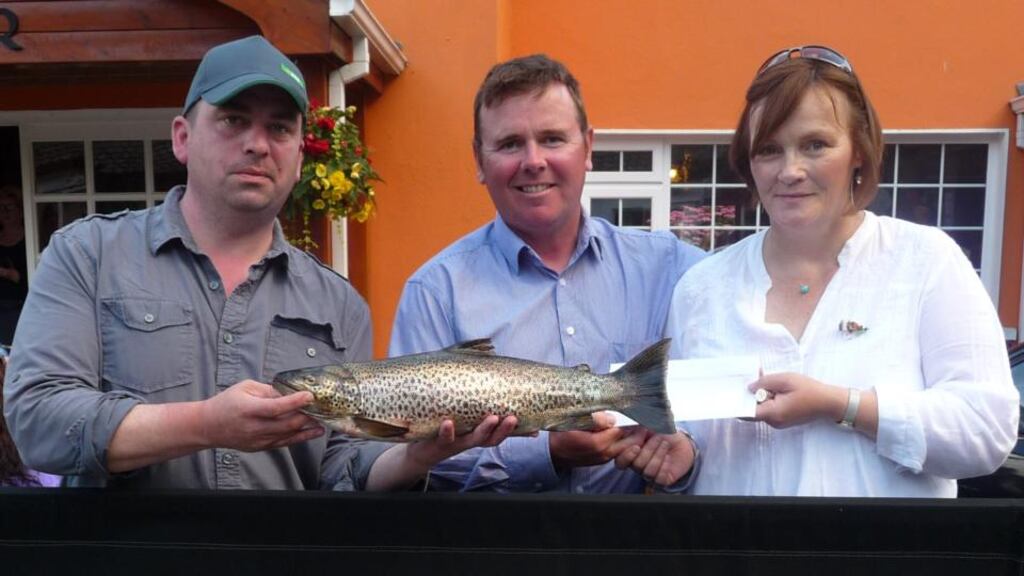 Peadar Gavin (left) winner of the Cong competition with a trout of 4.42lb alongside Phil Donoghue of Galway Autism Partnership accepting a cheque for €4,000 from Dorrie Gibbons (Cong)