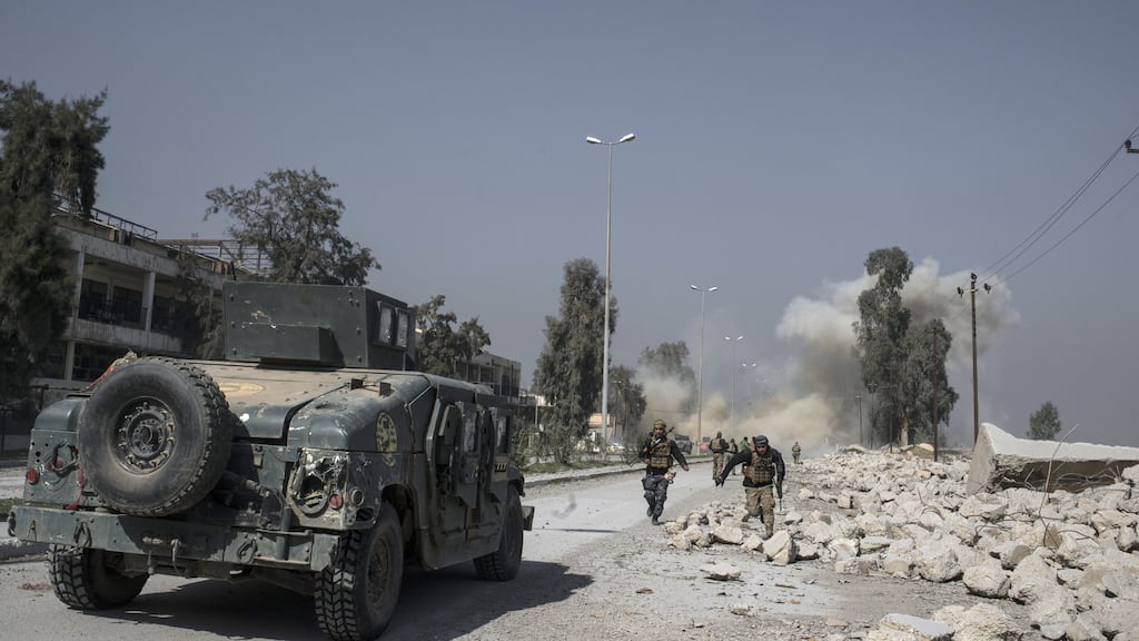 Iraqi officers run from a mortar attack by Isis militants near Mosul airport on Thursday. Photograph: Getty Images