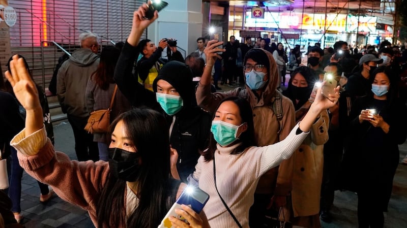 People raise lit up mobile phones as they form a human chain on New Year’s Eve in Hong Kong, on Tuesday. Photograph: Vincent Yu/AP Photo