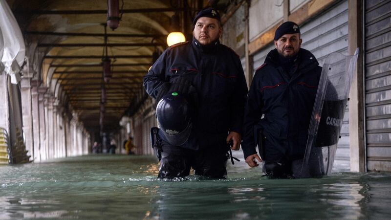 Carabinieri police officers patrol a flooded arcade by St Mark’s square on November 15th. Photograph: Filippo Monteforte/AFP via Getty