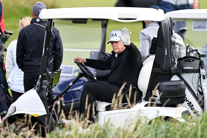 Donald Trump waves as he drives a golf buggy the Trump Turnberry golf courses in Turnberry, south-west Scotland, on Saturday. Photograph: Andy Buchanan/Getty