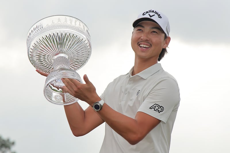 Min Woo Lee celebrates with the trophy after winning the Houston Open. Photograph: Jonathan Bachman/Getty