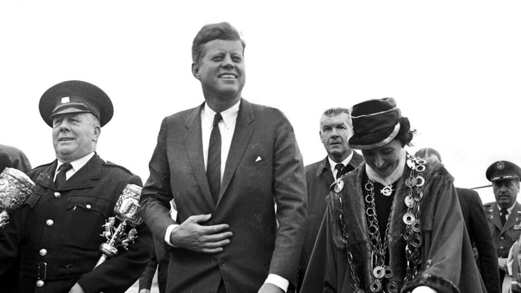 John F Kennedy, accompanied by the mayor of Limerick, Frances Condell, walks towards the platform at Greenpark Racecourse, Limerick.