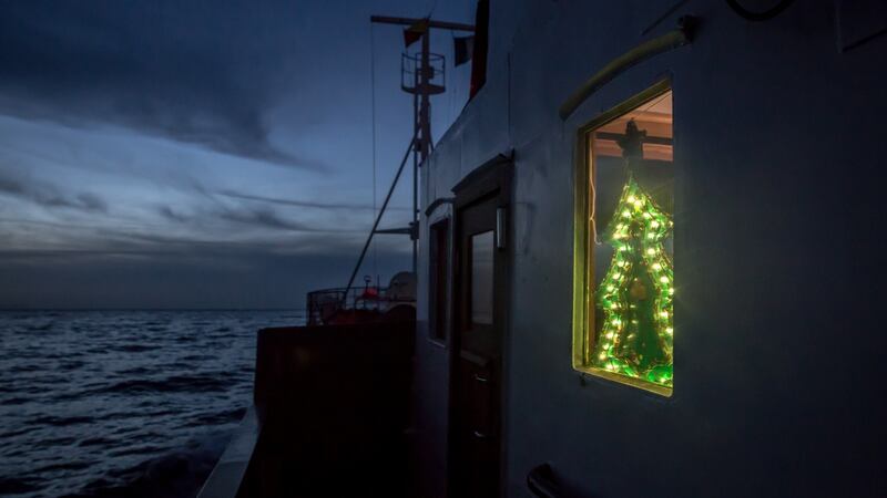 A Christmas tree light in the window of the Alan Kurdi rescue vessel. Photograph: Sally Hayden