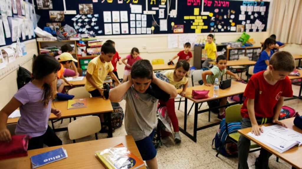 Israeli children leave their classroom for a bomb shelter as a siren sounds during a drill at a school in Pisgat Zeev, an urban settlement in an area Israel annexed to Jerusalem after capturing it in the 1967 Middle East war, May 27, 2013. Photograph: Reuters