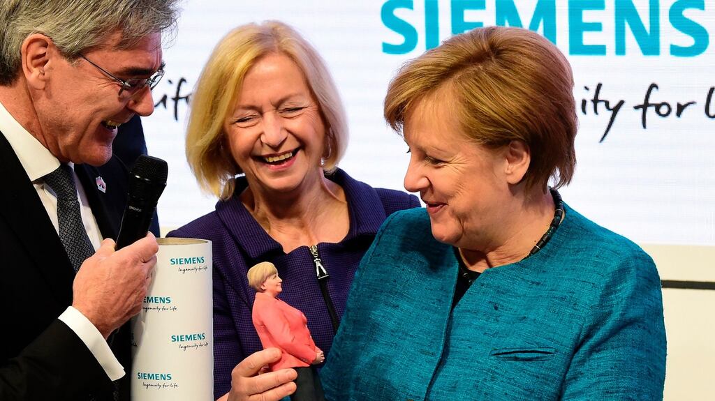 German chancellor Angela Merkel holds a 3D printed figurine of herself at the Hannover Messe trade fair. Photograph: Tobias Schwarz/AFP
