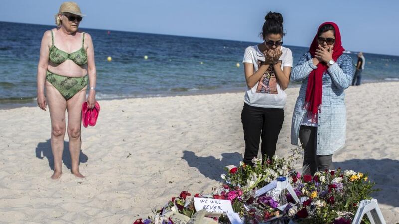 Women pray near bouquets of flowers laid on the beach of the Imperial Marhaba resort, which was attacked by a gunman, in Sousse on Sunday. Photograph: Zohra Bensemra/Reuters