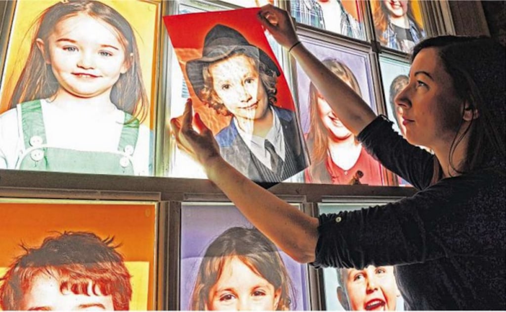 Portraits for the Ark: Aideen Lynch, visual arts co-ordinator at The Ark, adds the last portrait to Faces in the Window, a project featuring photographs of children. The exhibition marks the 21sth birthday of The Ark, Ireland's only cultural centre for children. Photograph: Eric Luke