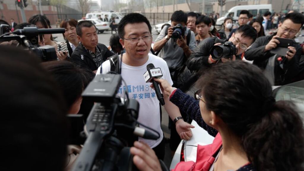 A relative of a passenger onboard Malaysia Airlines flight MH370 answers media questions outside the Malaysia embassy in Beijing yesterday. Photograph: Lintao Zhang/Getty Images