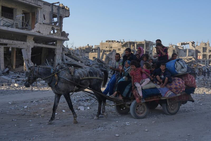 Palestinians on a horse-drawn cart loaded with belongings on Al-Jalaa Street in Gaza City. Photograph: Abdel Kareem Hana/AP