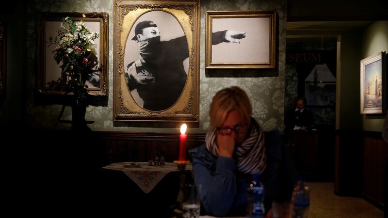 A woman sits at the Walled Off hotel which was opened by street artist Banksy, in the West Bank city of Bethlehem. Photograph: Ammar Awad/Reuters