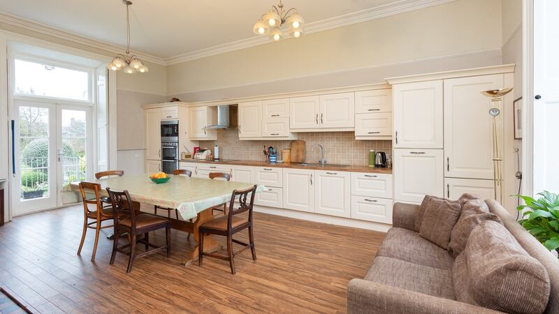 The large kitchen runs the full width of the house, and has French doors and steps to the rear garden