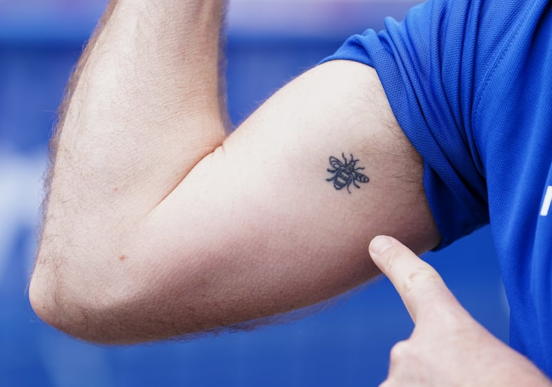 Andy Burnham shows his Manchester worker bee (symbol of Manchester) tattoo. Photograph: Martin Rickett/PA