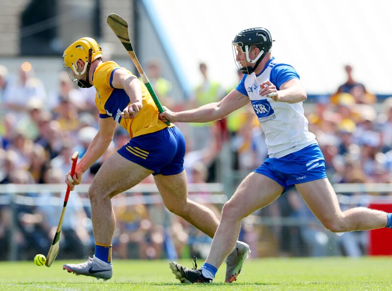 Clare’s Mark Rodgers scores his sides third goal despite Iarlaith Daly of Waterford. Photograph: James Crombie/Inpho