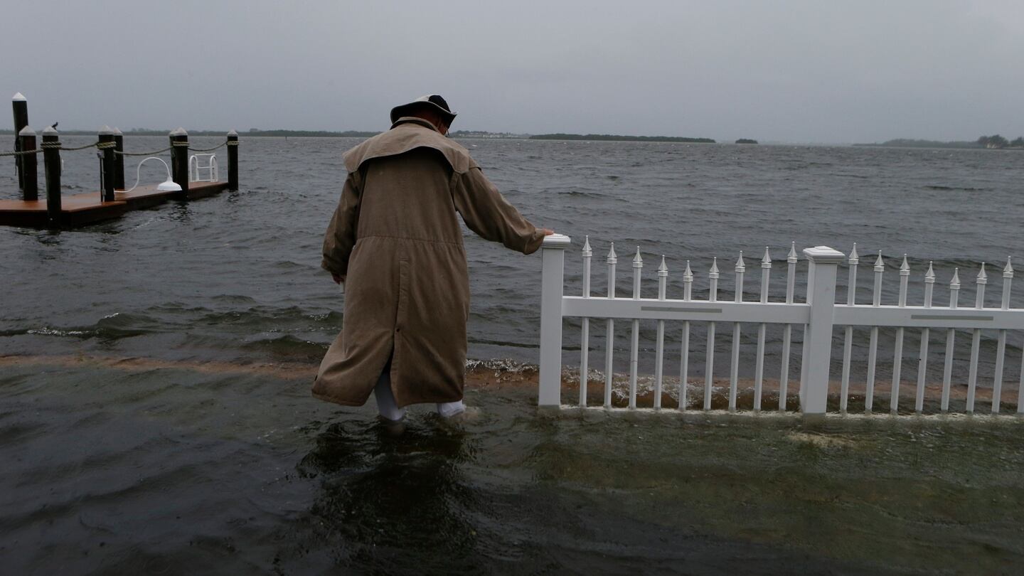 Doug LeFever inspects the seawall near his home at the Sandpiper Resort as he surveys the rising water coming from the Gulf of Mexico into his neighbourhood. Photograph: Brian Blanco/Getty Images