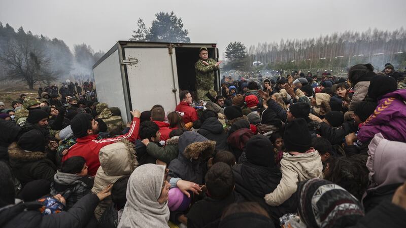 Migrants gather for humanitarian aid being handed out by the Belarusian military at the camp at the Belarus-Polish border in the Grodno region. Photograph: EPA