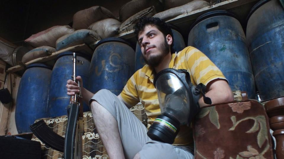A Free Syrian Army fighter holds a gas mask as he sits inside a house in the besieged area of Homs. Photogrpah: Yazan Homsy/Reuters