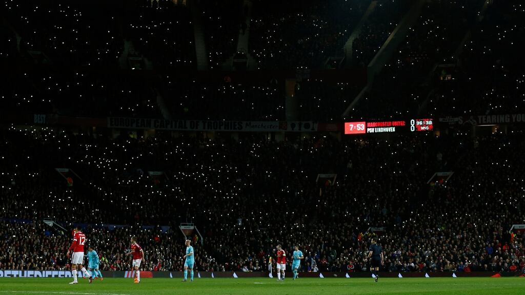 Manchester United fans wave their mobile phone lights during the seventh minute of the match in honour of former player George Best. Photograph: Phil Noble/Reuters/Livepic
