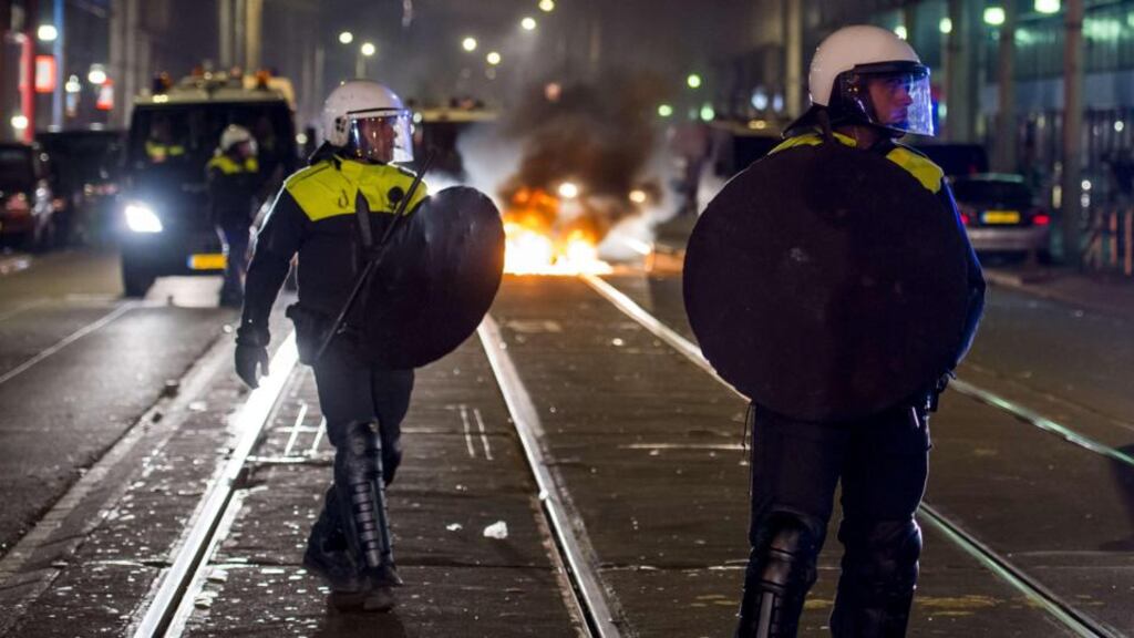 Riot police patrol in the Schilderswijk district of The Hague during the third night of riots following the death of a tourist in police custody. Photograph: Marco de Swart/AFP/Getty Images