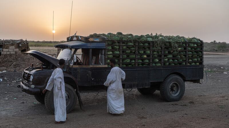 Men transporting watermelon stop for an iftar meal during Ramadan in the town of El-Kabashi. Photograph: Abdulmonam Eassa/The New York Times