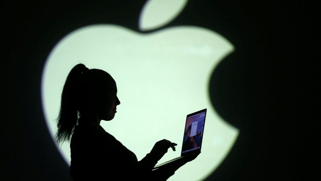 Silhouette of laptop user is seen next to a screen projection of Apple logo. Apple has released a software update across all platforms to bring its services fully into line with the new GDPR (General Data Protection Regulation) rules.  PHOTOGRAPH: Dado Ruvic/Reuters
