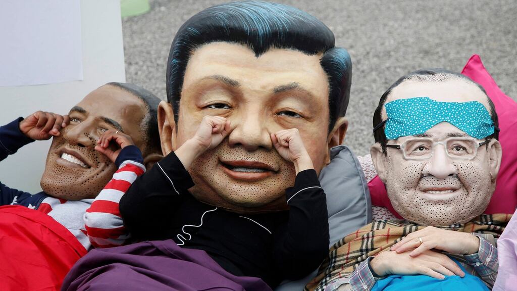 Oxfam activists  wearing masks depicting some of the world leaders outside the climate conference venue in France. Photograph: Jacky Naegelen/Reuters