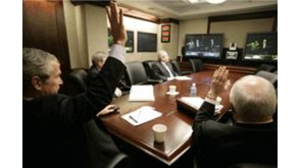 President George Bush and vice-president Dick Cheney wave to
Iraqi prime minister Nouri Al-Maliki during a video teleconference
in the situation room of the White House yesterday. Photograph:
Eric Draper/White House via Getty Images