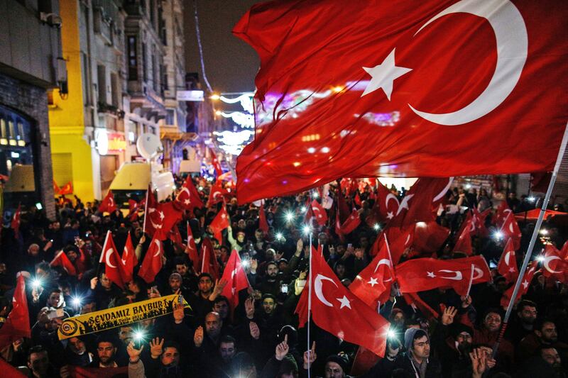 Protesters wave flags outside the Dutch consulate in central Istanbul's Istiklal Avenue, the main shopping road of Istanbul on Sunday morning. Photograph: AP