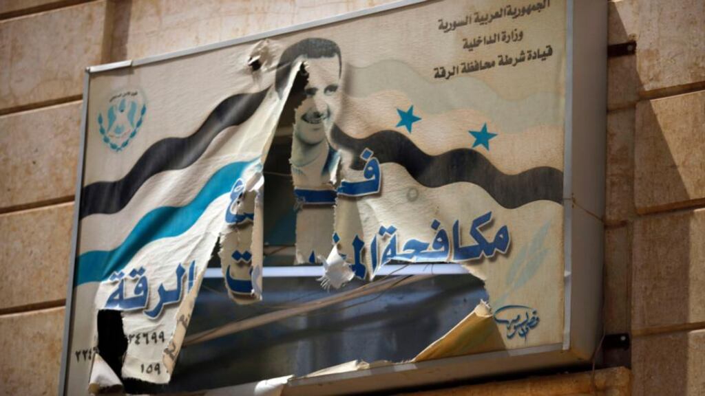 A torn poster of Syria’s president Bashar al-Assad on a government building in Raqqa province, east Syria yesterday. Photograph: Hamid Khatib/Reuters