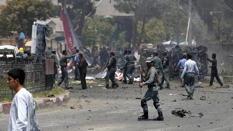 Policemen inspect the site of a car bomb blast at the entrance gate to the Kabul airport, Afghanistan. Photograph: Muhammad Ismail/Reuters.