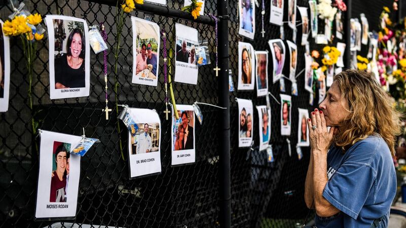 A woman prays in front of photos at the makeshift memorial for the victims of the building collapse. Photograph: Chandan Khanna/AFP/Getty Images