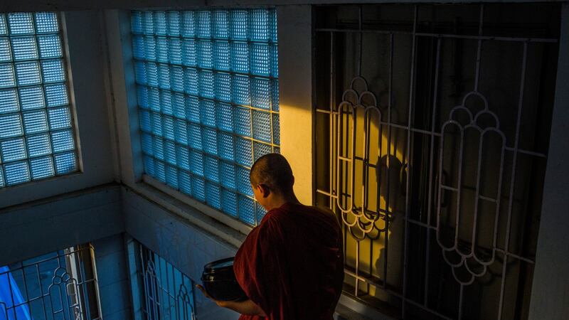 A Buddhist monk leaves the New Masoeyein monastery to collect alms, in Mandalay, Myanmar. Photograph: Minzayar Oo/The New York Times