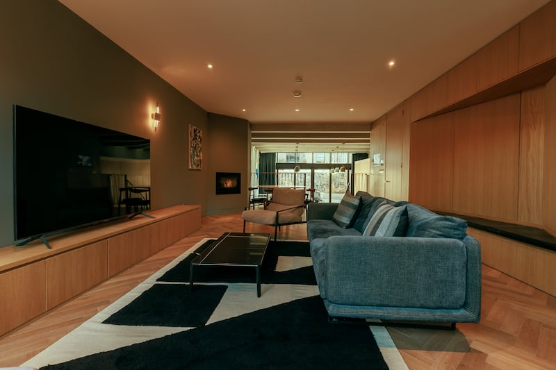 Open-plan livingroom area with oak flooring and a wall of oak cabinets for maximum storage